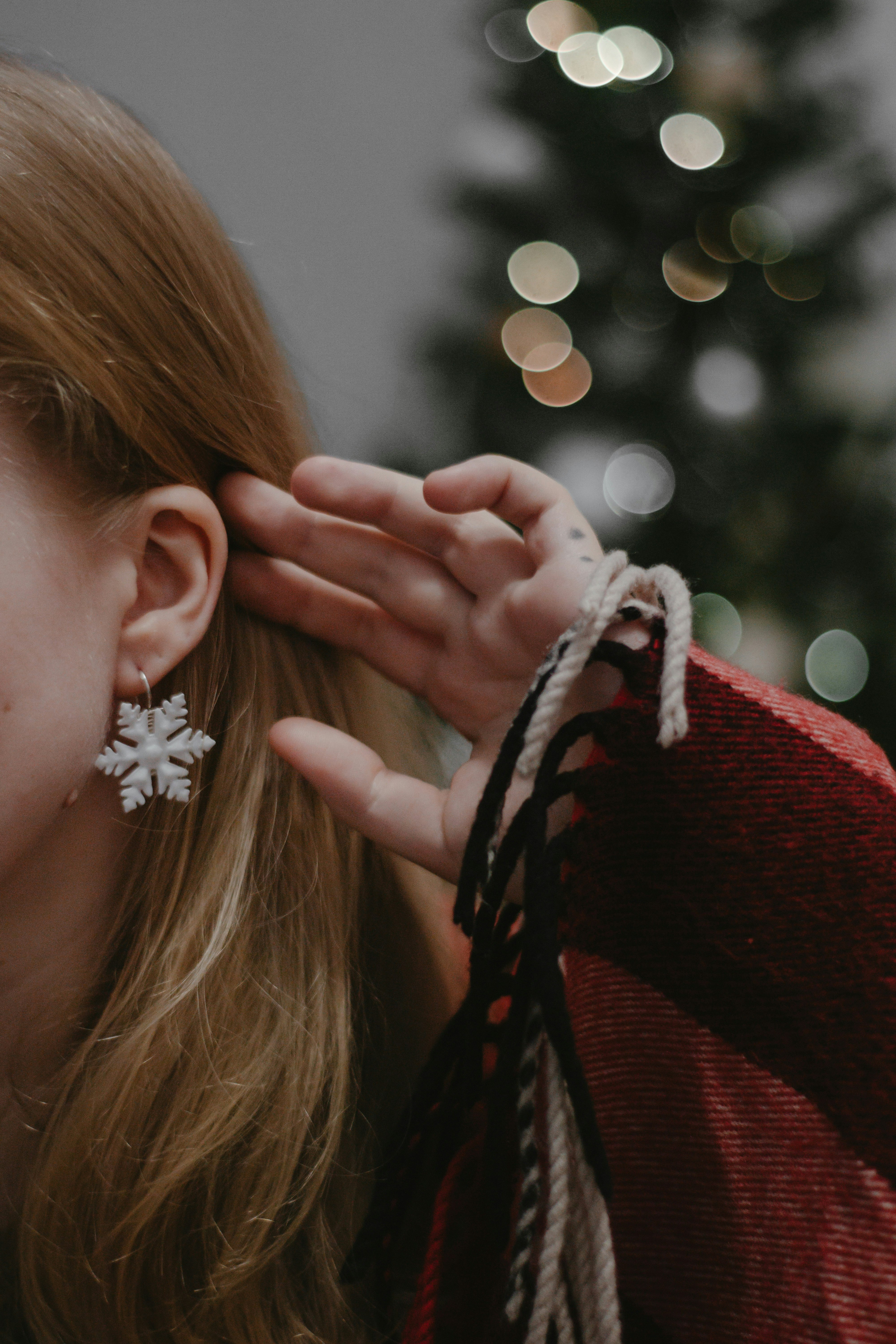 woman in red and black long sleeve shirt with white flower on her ear